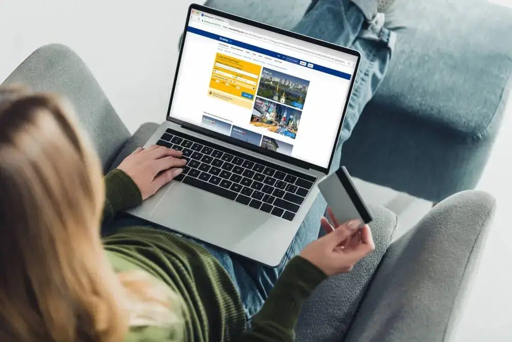 A person's hand pressing a "SKYROCKET SALES" button on a laptop with charts in the background, illustrating website conversion optimisation