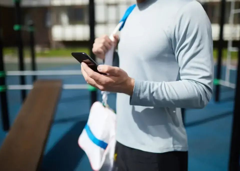 athlete reviewing cpa in digital marketing metrics on a sports app on his smartphone after training.