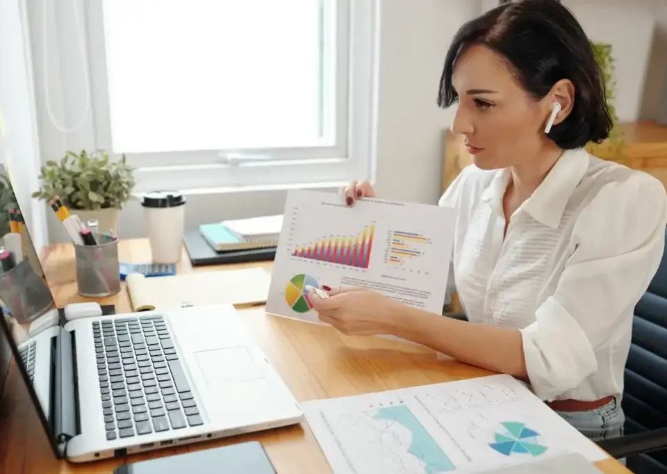 marketing professional analysing data with 'what is a digital marketing strategy' chart on desk.