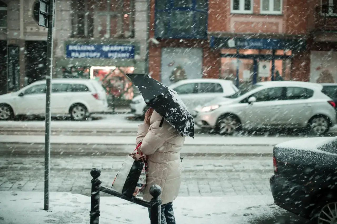 A person in a raincoat and umbrella stands in the rain, with a thought bubble above them reading "Weather Based Marketing"
