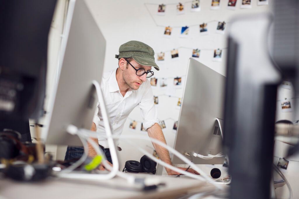 A magnifiying glass scans over charts and graphs on a laptop screen, emphasizing the detailed analysis involved in an SEO audit