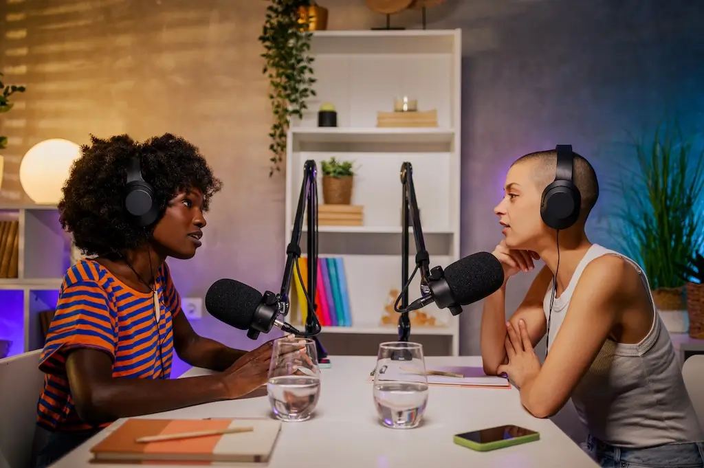A collection of podcast microphones and headphones on a desk, representing the top digital marketing podcasts